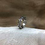   Anillo de plata de ley, de superficie labrada con motivos inspirados en la flor de lis, símbolo de honor y lealtad. 
